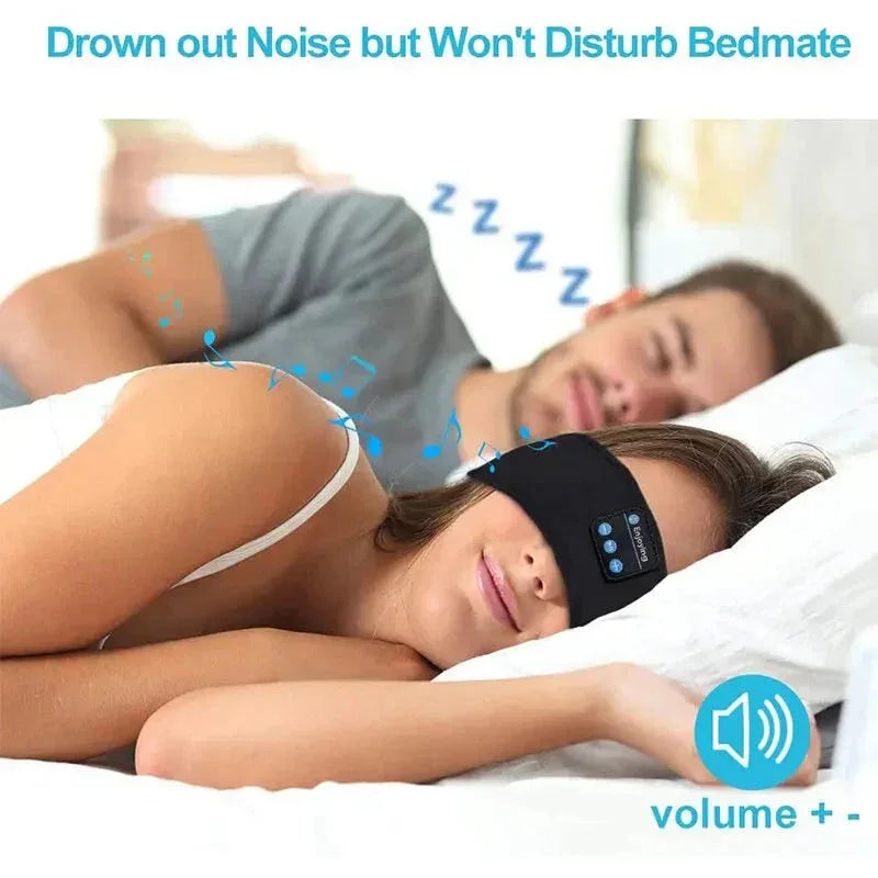 Woman wearing black bluetooth sleep headband lying in bed next to sleeping man with music notes