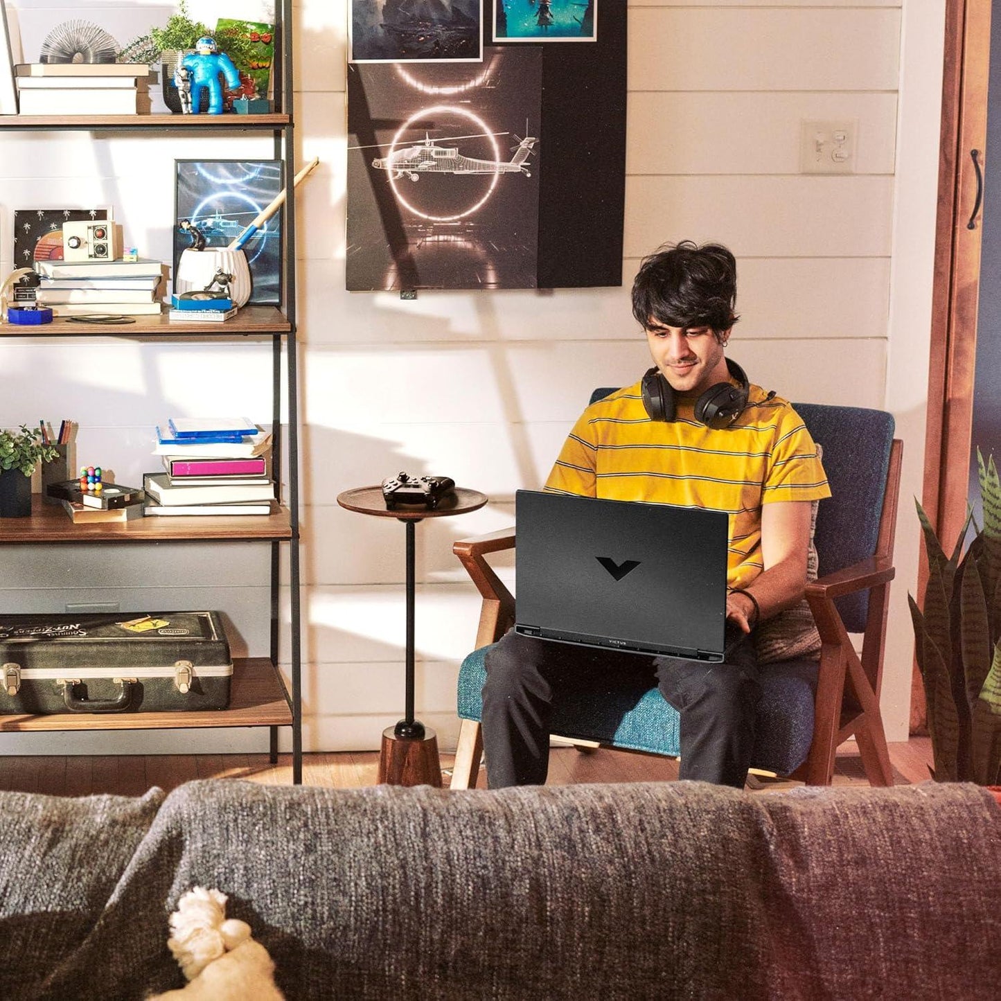 Young man using Victus 15.6 inch gaming laptop from TechNest in a cozy living room